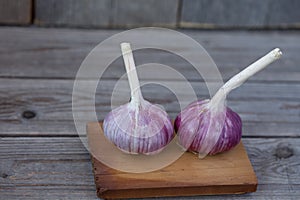 Two garlic on a wooden background close up
