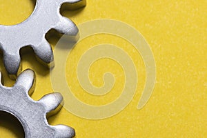 Two gears geared on a yellow background with copy space, geared steel sprockets, sprocket, background with gearing parts