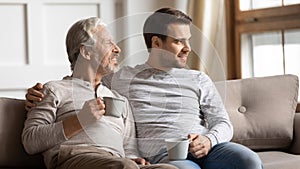 Two generations family enjoying free time with cup of tea.