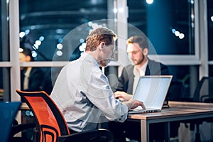 Two gentlemen staying up late in office working.