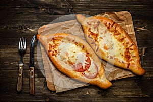 Two Georgian khachapuri close-up on the wooden table.