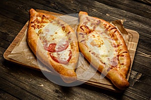 Two Georgian khachapuri close-up on the wooden table.