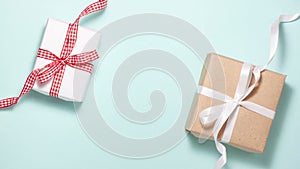 Two gift box with a red and white ribbon bow on blue background. Flat lay top view stop motion animation