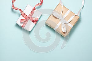 Two gift box with a red and white ribbon bow on the top on blue background. Flat lay top view with space for text.