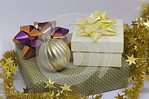 Two gift boxes and a golden ball, beads on a light background