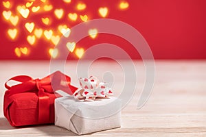 Two gift boxes on the table with copy space for valentine's day celebration with red colored background