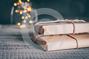 Two Gift or present box wrapped in kraft paper on wooden table and defocused holiday lights