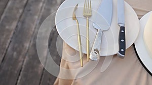 Two gilded forks and a knife for a cake on a white plate around the wedding cake.