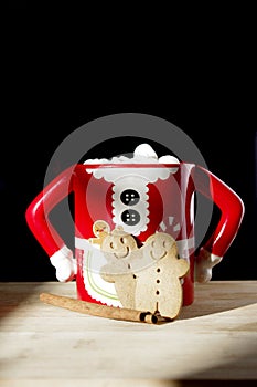 Two gingerbread cookies in a hot chocolate Mrs. Clause cute mug with marshmallows