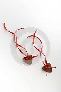 Two gingerbread hearts on Valentines Day with red ribbon on white background. Vertical frame