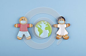 two gingerbread man medics in a mask girl and boy, gingerbread planet earth in the middle