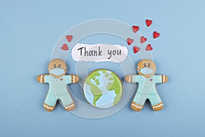 two gingerbread man medics in a mask with the inscription thank you and a lot of red hearts, gingerbread planet earth