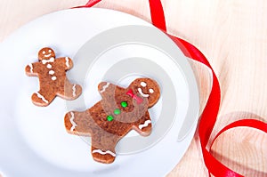 Two gingerbread men on a plate.