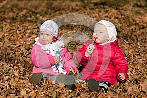 Two girl blowing bubbles outdoors