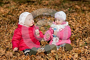 Two girl blowing bubbles outdoors