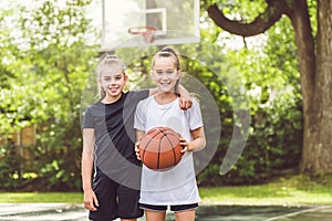 two girl child in sportswear playing basketball game