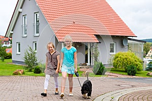 Two girl or children walking with dog