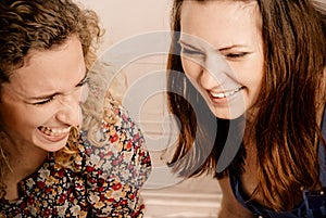 Two girl friends laughing gleefully