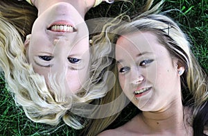 Two girl friends laying in grass