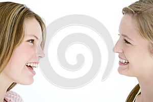 Two girl friends looking at each other smiling