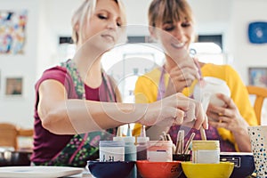 Two girl friends painting their own handmade ceramics