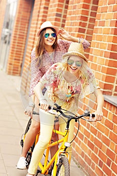 Two girl friends riding tandem bicycle