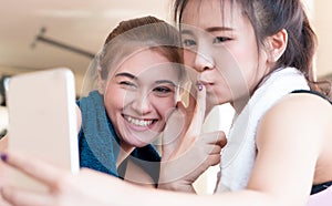 Two girl friends taking selfie while taking a break from working out