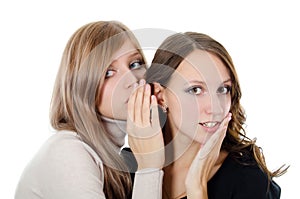 Two girl-friends tell gossips on an ear