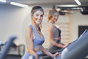 Two girl friends working out on treadmill