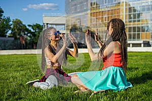 Two girl friends with zizi cornrows dreadlocks giving high five to each other