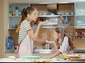 Two girl making dough in the home kitchen. photo