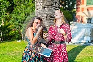 Two girl talking and laughing on their smartphone