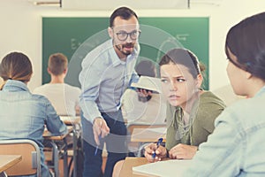 Two girl are talking in time lecture and teacher is disturbance it photo