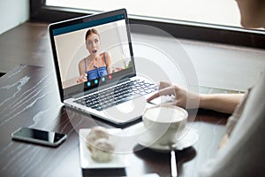 Two girlfriends chatting on laptop via video call application.