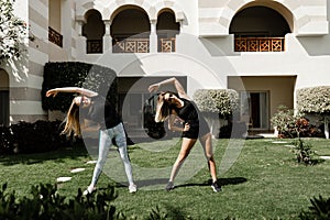 two girlfriends do outdoor exercise