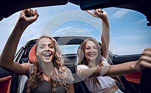 Two girlfriends enjoying a trip in the car