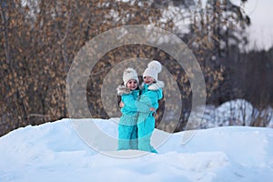 Two girlfriends have fun. Winter walks of girls in the woods, good weather. Joyful meeting and hugs