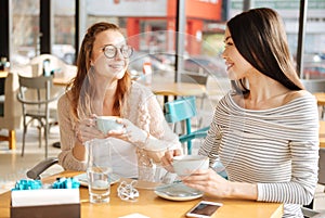 Two girlfriends having conversation at cafeteria