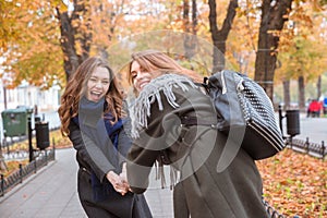 Two girlfriends having fun in autumn park