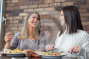 Two girlfriends having lunch together at a restaurant