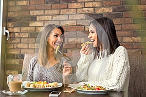 Two girlfriends having lunch together at a restaurant