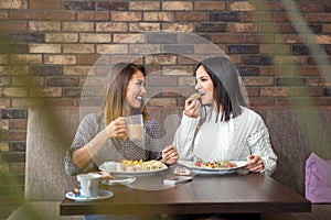 Two girlfriends having lunch together at a restaurant