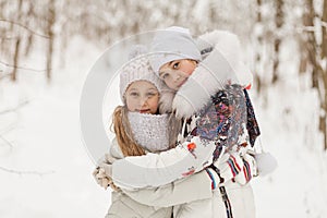 Two girlfriends playing in a winter forest.