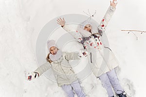 Two girlfriends playing in a winter forest.