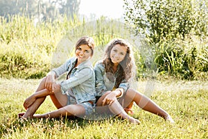 Two girlfriends sitting on grass