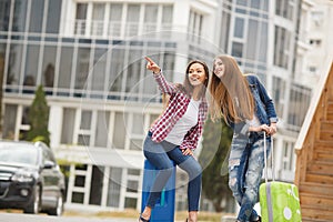 Two girlfriends with suitcases awaiting departure at the airport