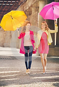 Two girlfriends walking during windy day