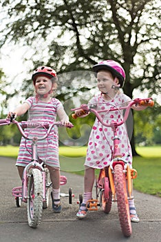 Two girls (3 & 5) on push bikes