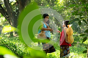 Two girls Asian women with traditional clothing stand in the rainforest.