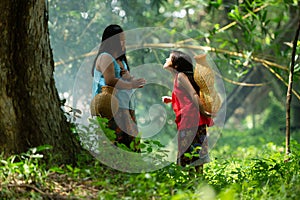 Two girls Asian women with traditional clothing stand in the rainforest.